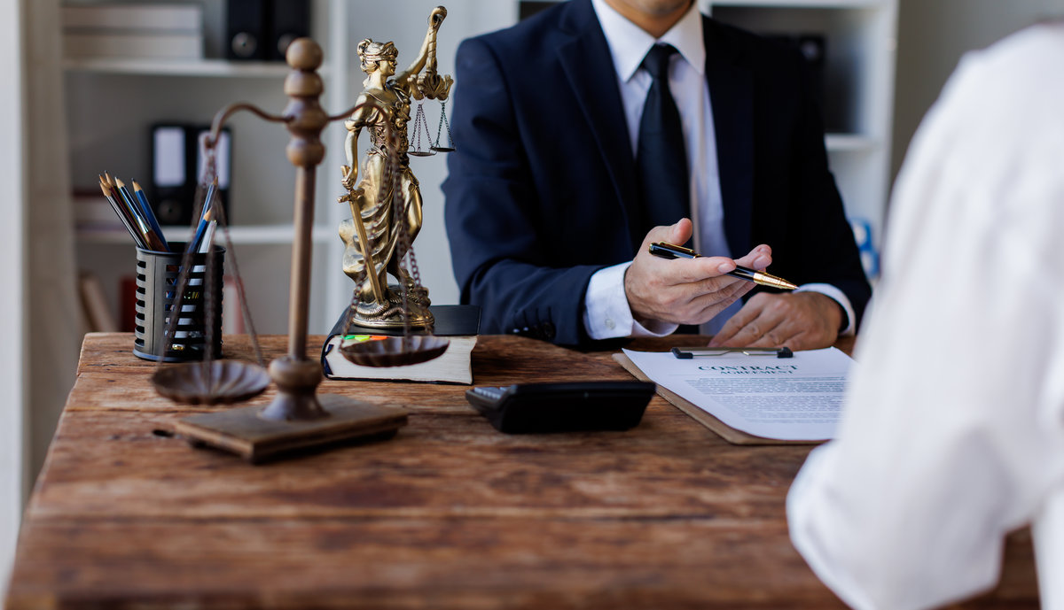 Two lawyers Consultation and conference discussing legal matters at a desk with a gavel, scales of justice law symbolizing law and justice, justice and lawyer Business partnership meeting concept.